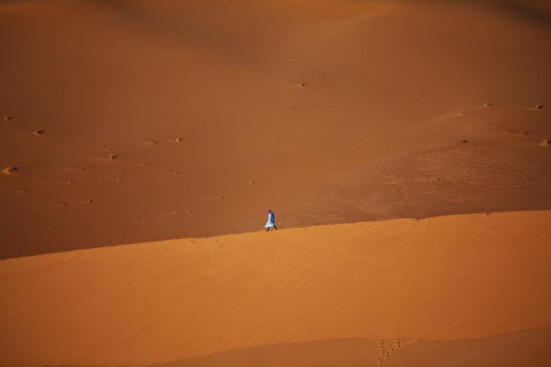 金黄色的沙漠上行走的一个人
