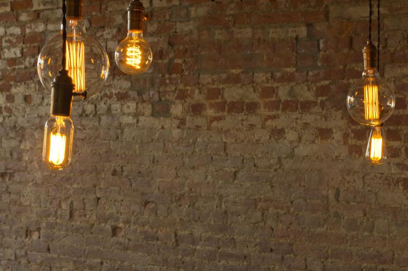 旧墙面前发亮的电灯泡
