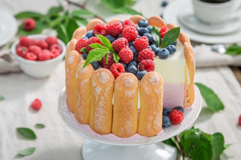 白色背景上的美味的蓝色和红色浆果蛋糕