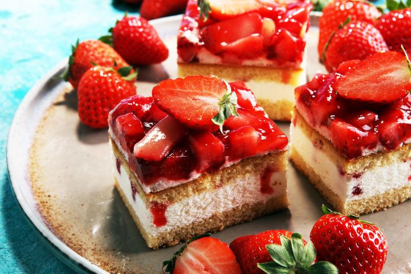 淡蓝色背景上的新鲜草莓蛋糕