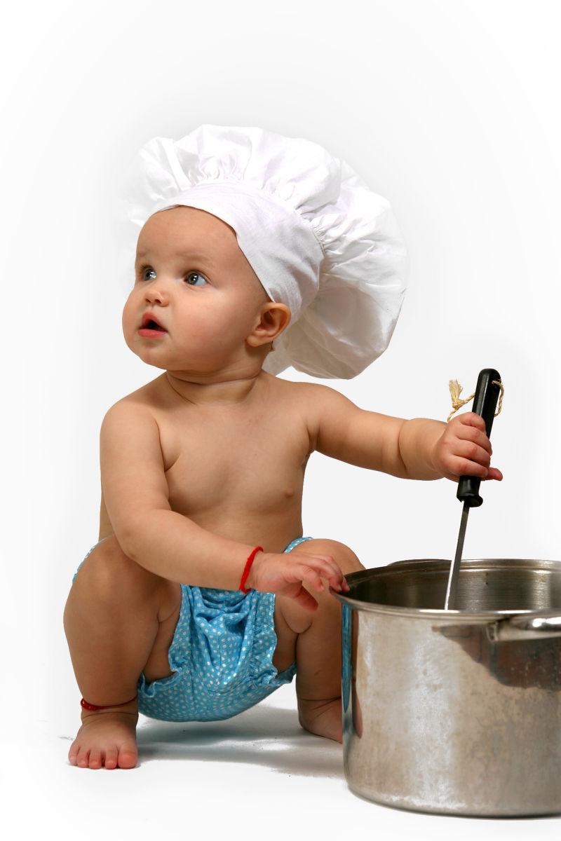 白色背景中带着厨师帽做饭的孩子