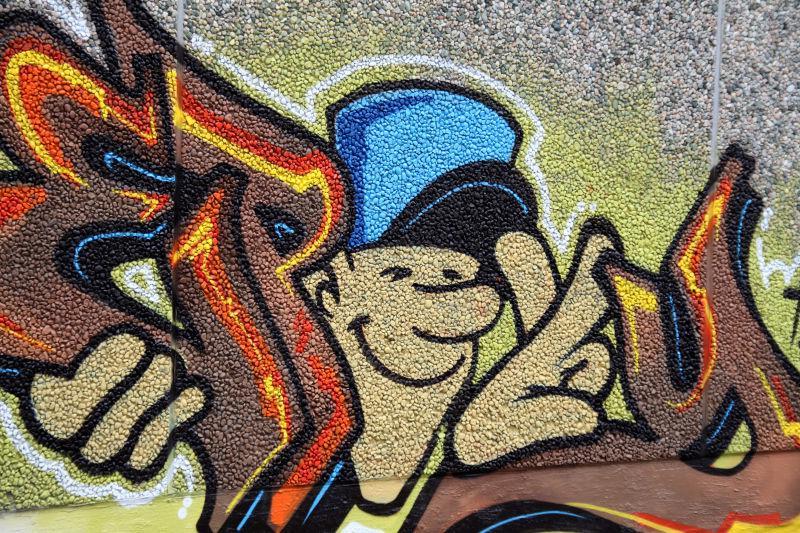 墙壁上戴着蓝色帽子微笑的男人涂鸦