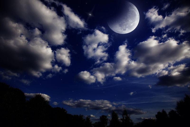 黑夜里有云的和月亮的天空