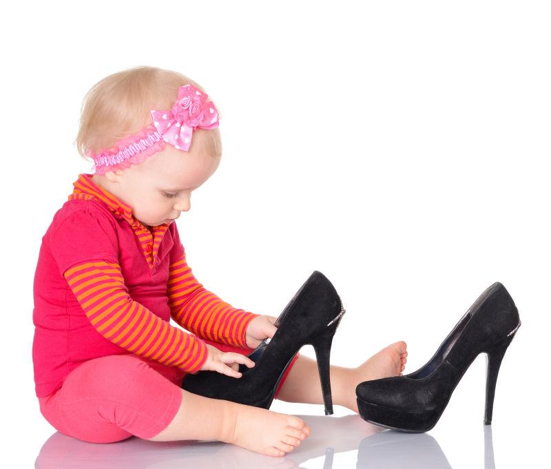 可爱的小女孩儿在试穿母亲的鞋子