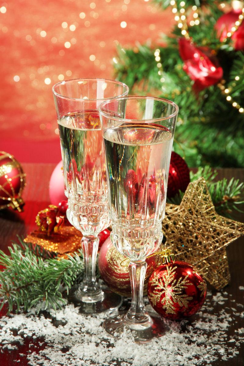 圣诞树边倒着香槟酒的杯子
