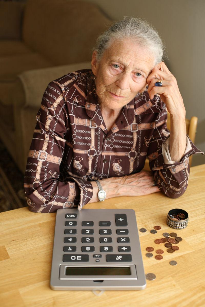 老人前面桌子上计算机和硬币