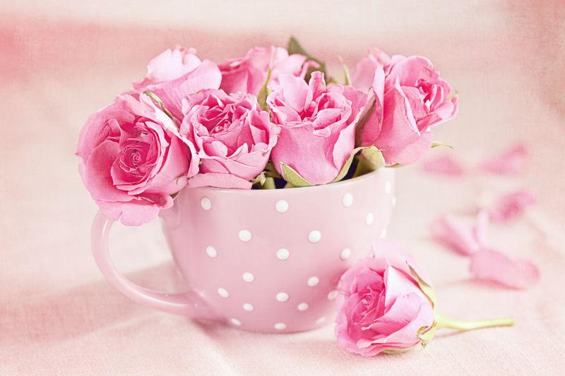 粉红色杯子里的玫瑰花束