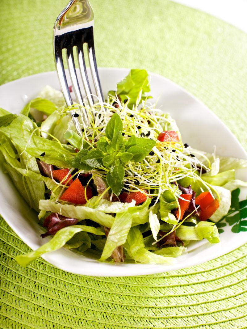 绿色桌上的叉子绿盖沙拉