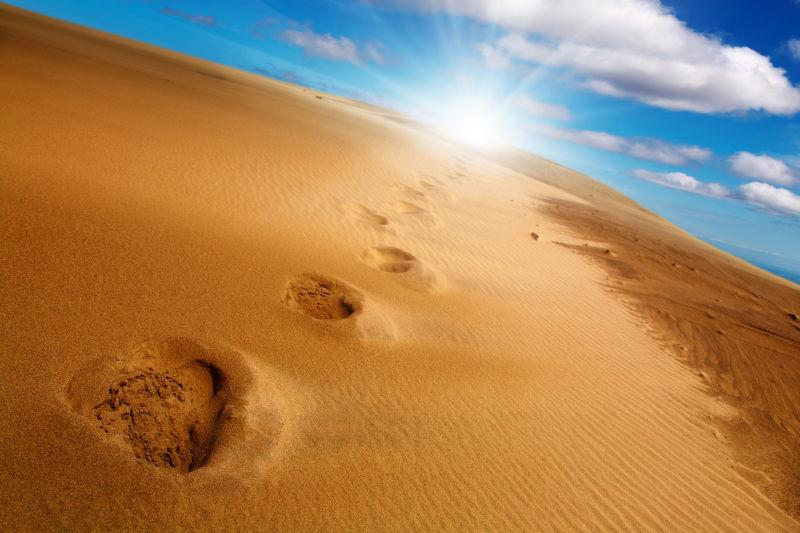 蓝天下沙丘上的足迹