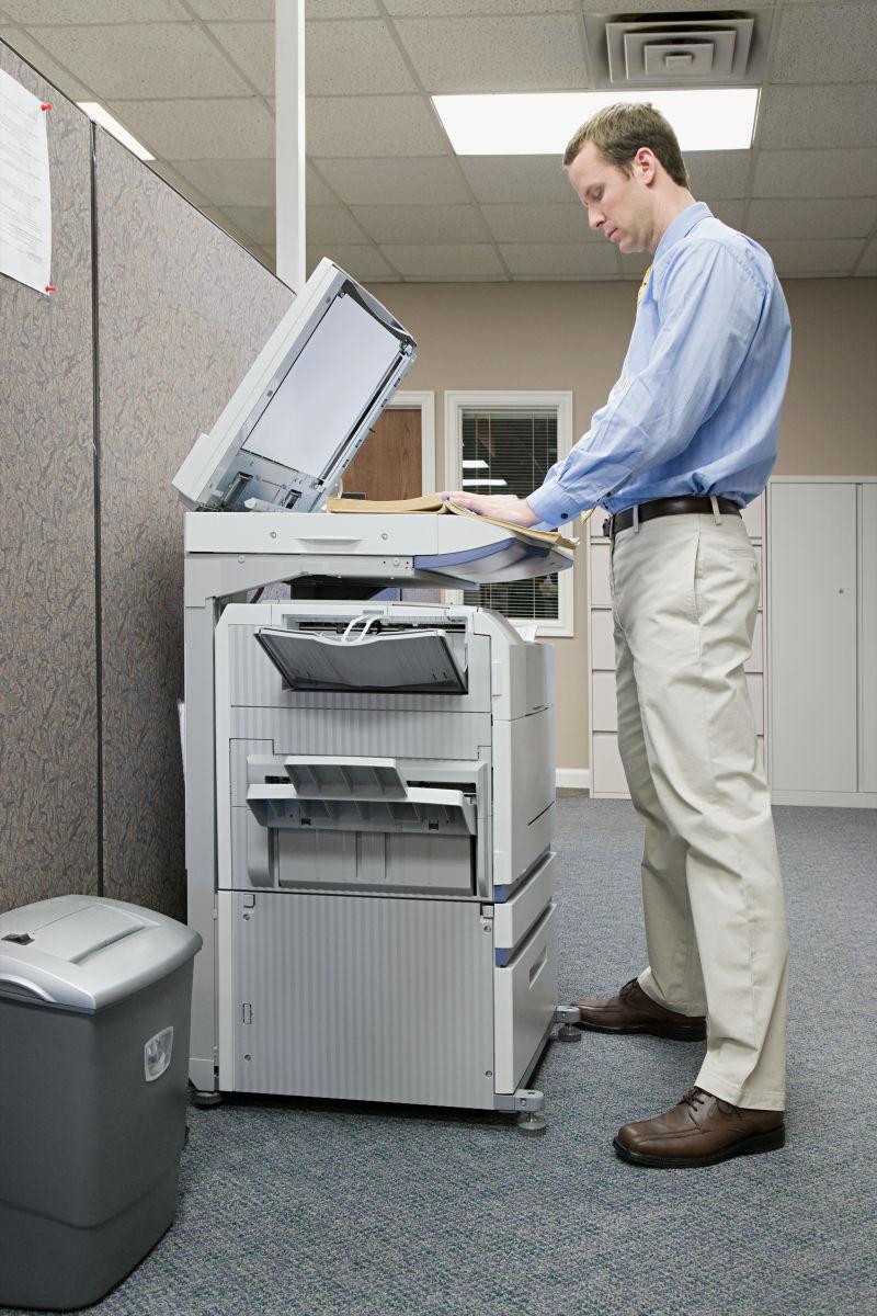 办公室里使用印刷机的男人