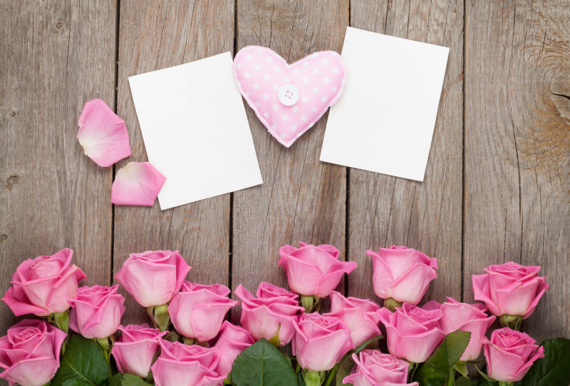 木桌上情人节空白贺卡和粉红玫瑰