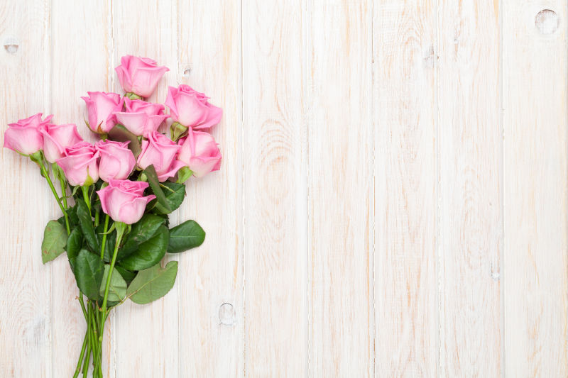 粉红玫瑰花束在木桌上