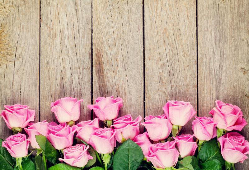 粉红玫瑰花束在木桌上摆放