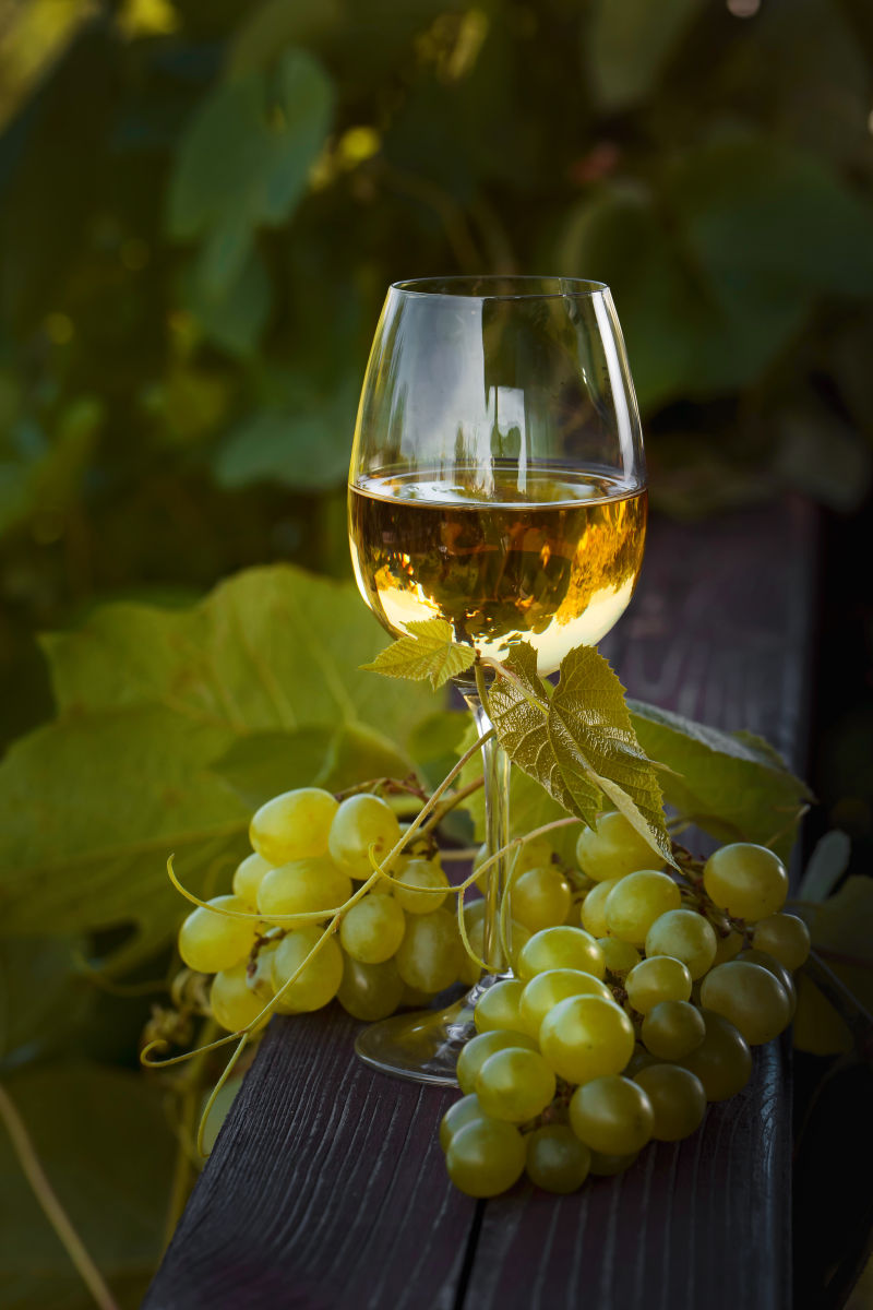 木板上的白葡萄酒与葡萄