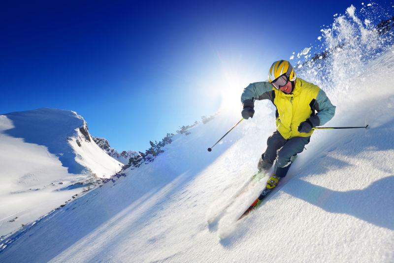 蓝天下阳光前雪地上的滑雪者