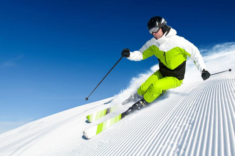晴朗的蓝天下在平整的雪地上滑雪的人