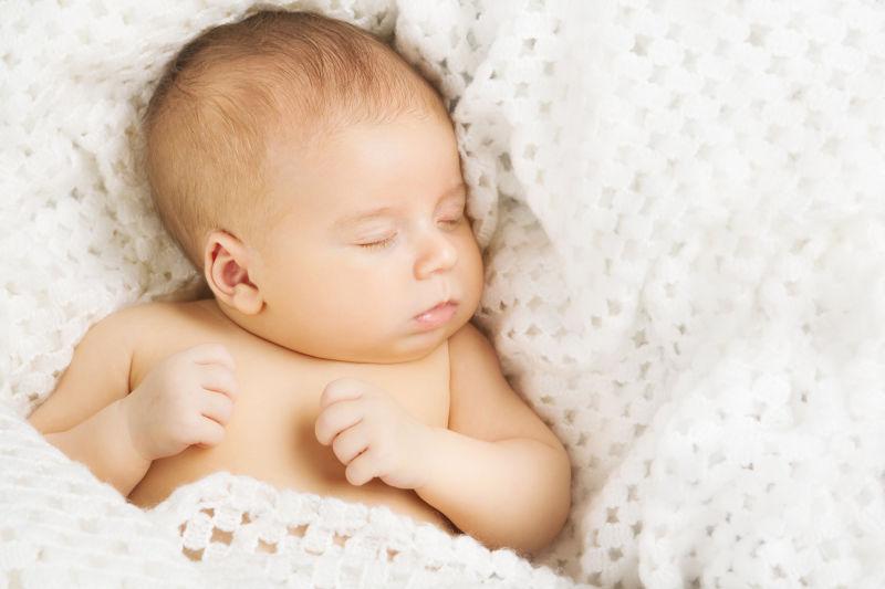 婴儿新生睡在白色毛毯上