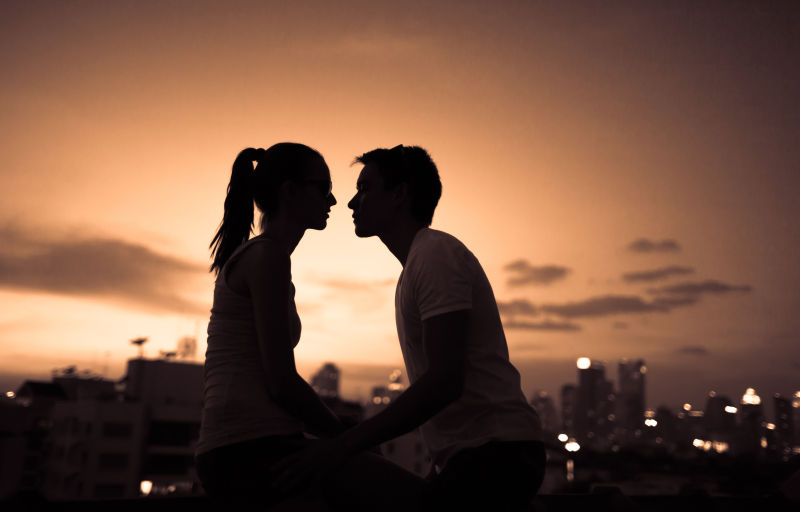 城市背景下浪漫的年轻夫妇在亲吻