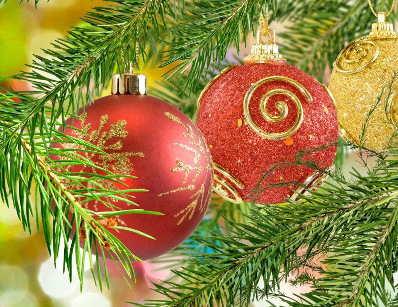 圣诞树背景下的金色和红色的圣诞装饰球