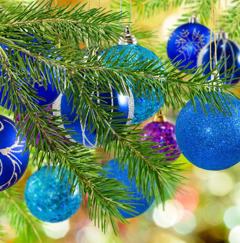 圣诞树枝旁的金色和紫色的圣诞装饰球