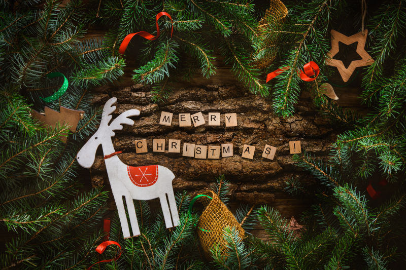 木头背景中圣诞树边框装饰和白色小鹿