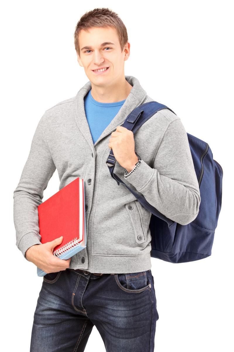 背着背包拿着书的男大学生