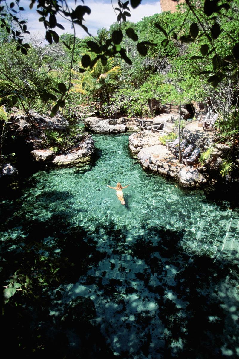 在墨西哥户外自然泳池里游泳的女人