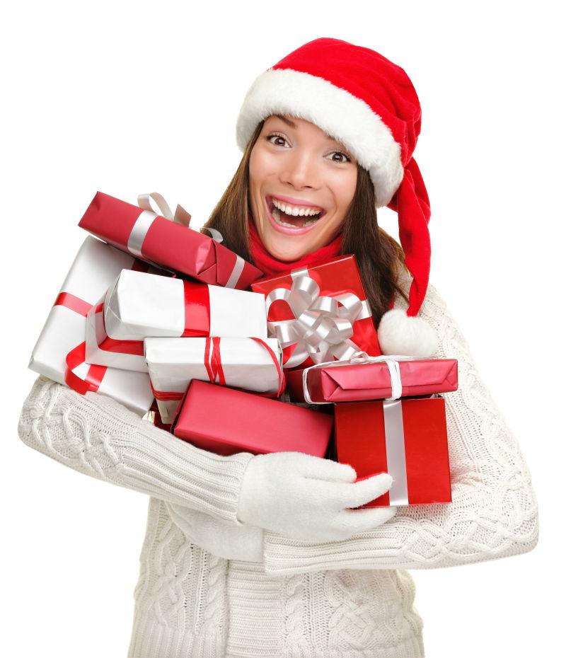 白色背景下抱着礼物的戴圣诞帽的美女