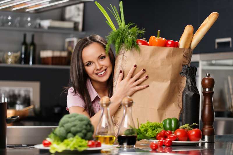 西方美女在厨房抱着蔬菜