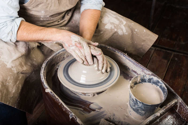陶瓷艺术概念与粘土原料和人动手陶轮特写