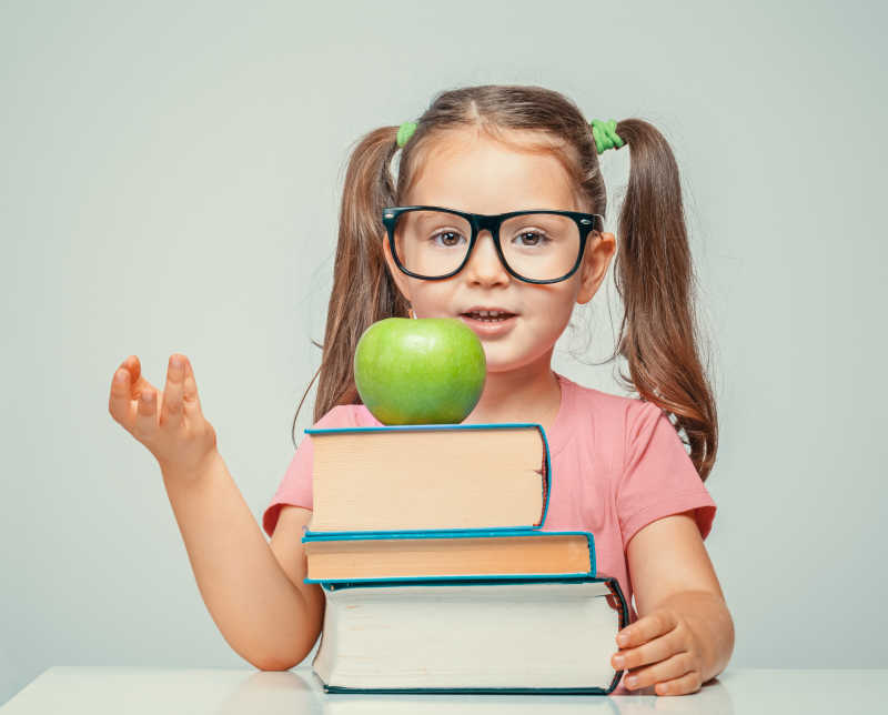 美丽可爱的小女孩喜欢读书学习就像她喜欢苹果一样
