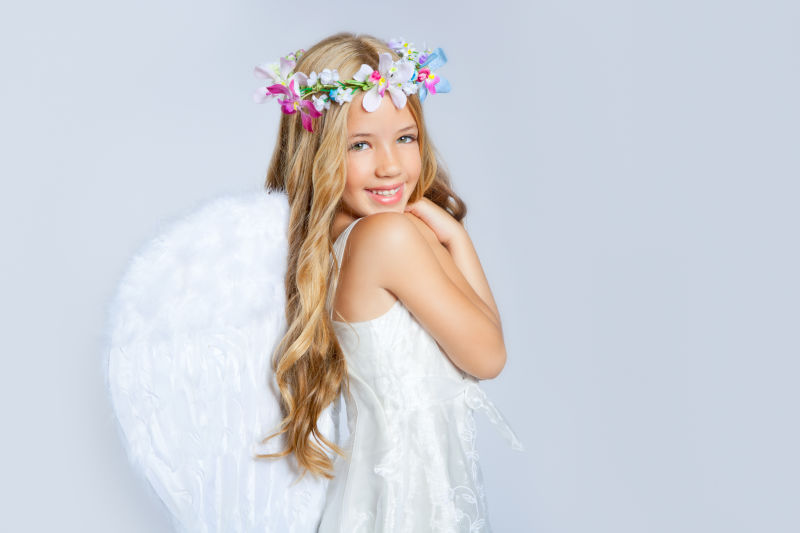 带着白色翅膀和花冠的天使小女孩