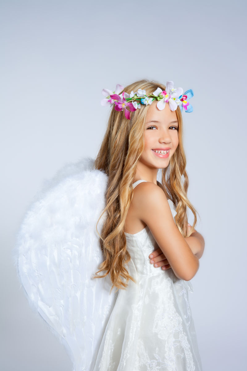 带着白色翅膀和花冠的天使小女孩