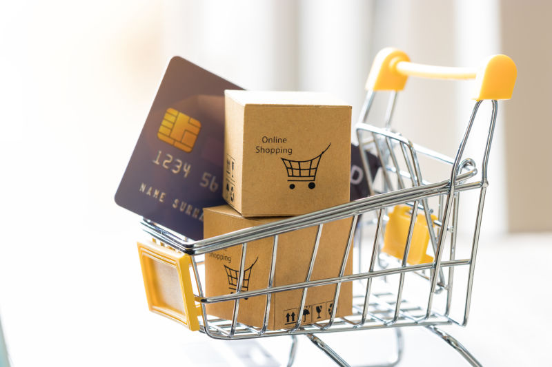 在手推车里堆满纸板箱和网上购物和信用卡模型-消费者可以随时随地直接从卖家处购买产品-网上购物和电子商务概念