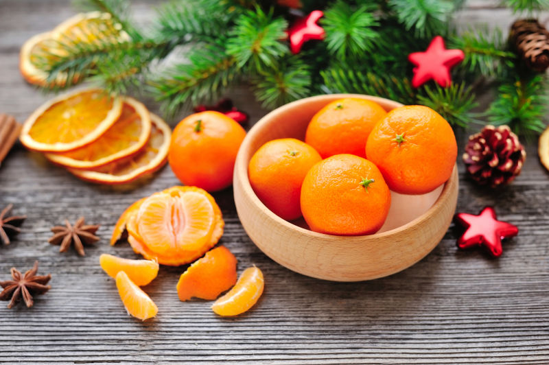 橘子和圣诞树的树枝放在一张木桌上-天然圣诞装饰