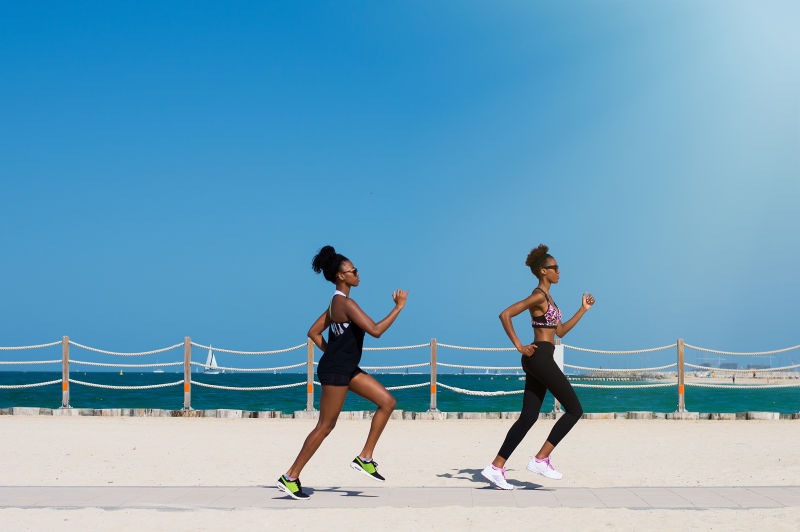 联合酋长国迪拜海滩上的两名非洲女性慢跑