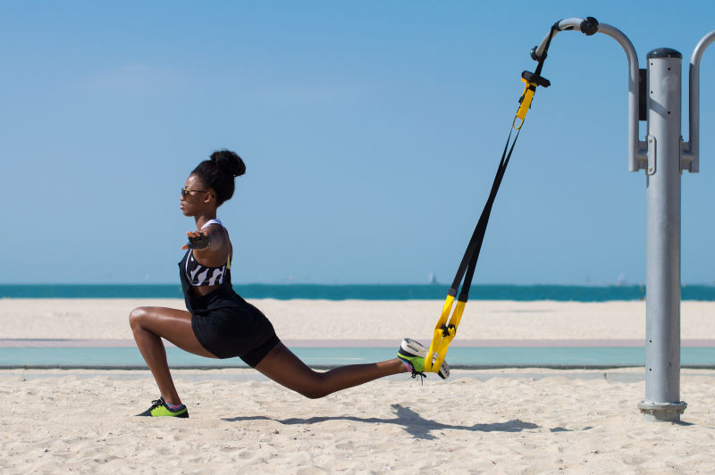 非洲女运动员在悬吊训练器的帮助下保持平衡户外运动
