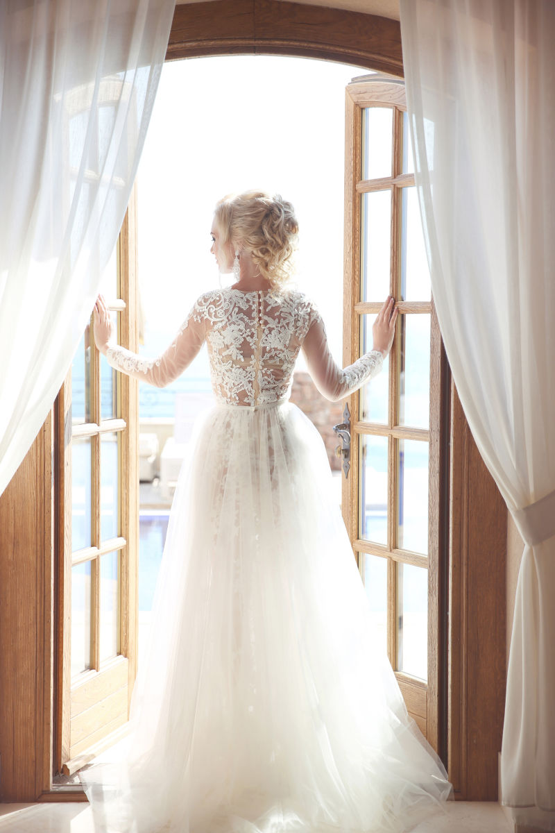 年轻的新娘穿着华丽的婚纱穿着宽大的裙子