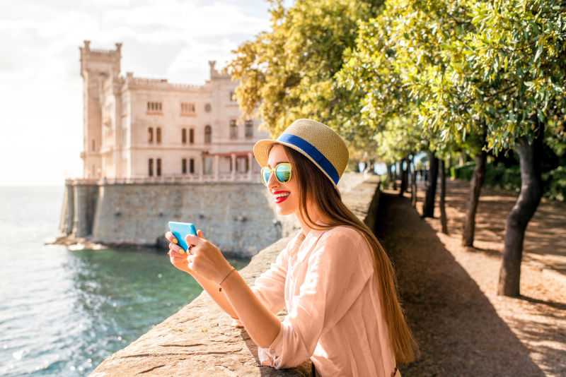 意大利东北部米拉马雷城堡附近的一位年轻女子在拍摄风景时很开心在意大利旅行