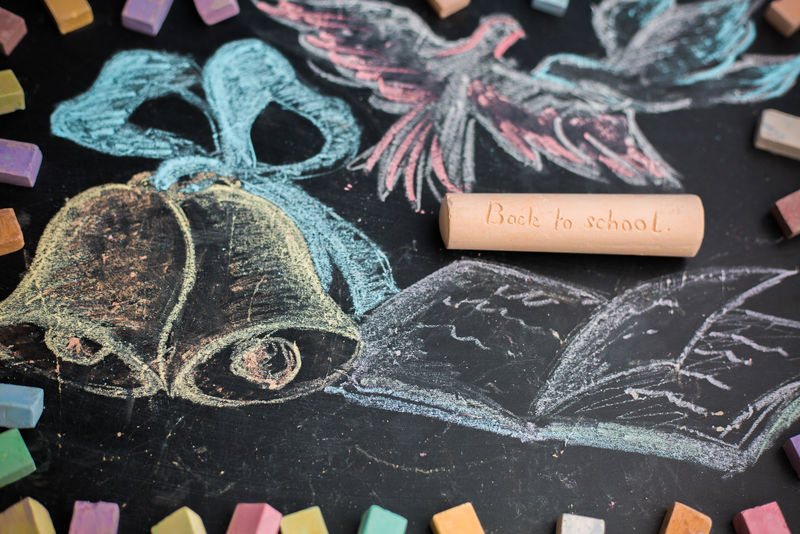 黑板上的学校概念粉笔画铃铛和笔记本
