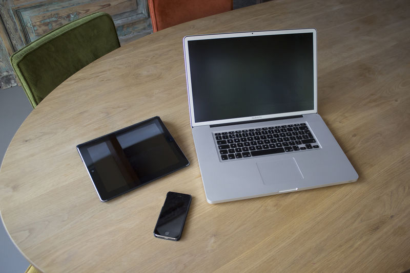 浅色木块上的笔记本电脑平板电脑和手机的创意俯视图