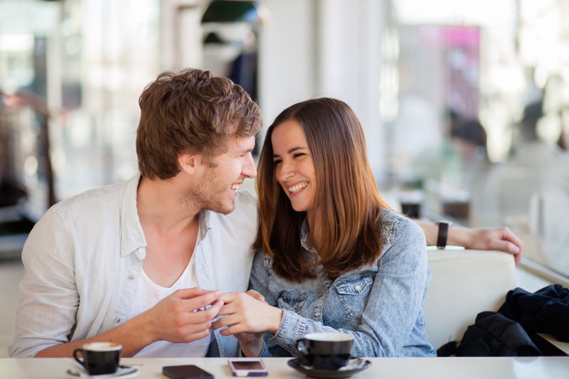年轻夫妇在咖啡店微笑的坦诚形象
