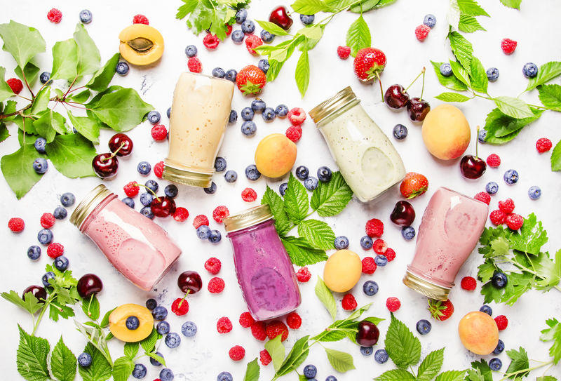 健康实用的彩色浆果可可塔利冰沙和奶昔-搭配酸奶新鲜水果和浆果-放在灰色桌子上-俯视图