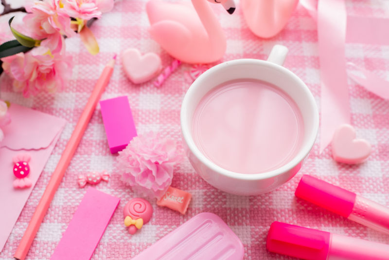 情人节的节日庆祝活动在粉色桌布背景上放上一杯草莓牛奶和丝绒装饰