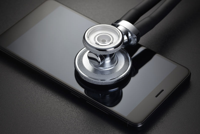 听诊器和黑色背景的智能手机-电话维修或在线医疗诊断结果概念