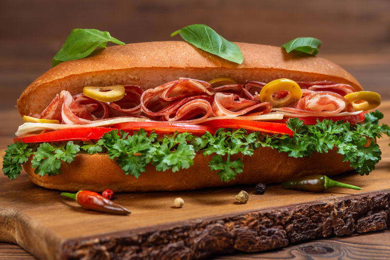 自制奶酪汉堡包的特写镜头-蔬菜香料和深木背景的火腿