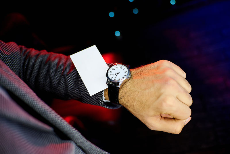 一张空白的白色名片-放在靠近时钟的人的手上-铭文的位置-复制空间