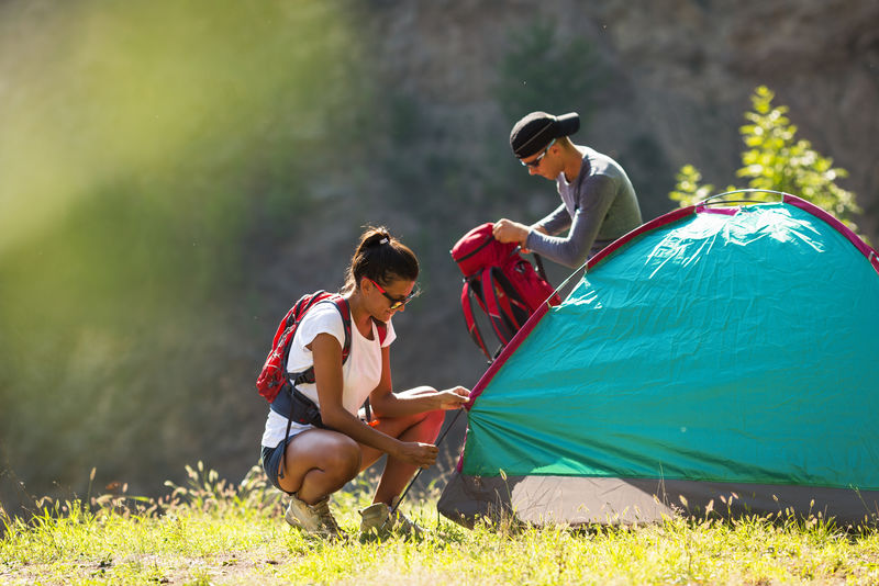 这对年轻夫妇在户外搭帐篷远足和野营搭帐篷
