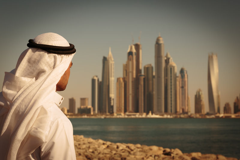 阿联酋迪拜码头的现代建筑穿着长裙的男人