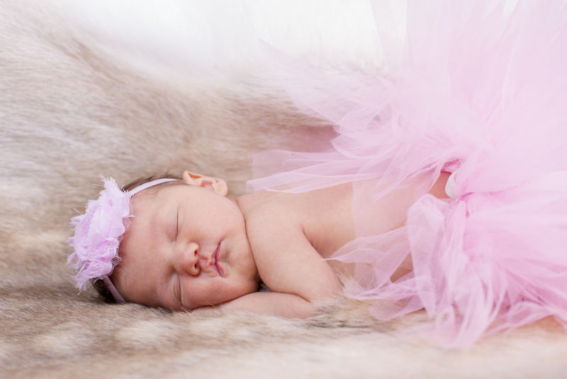 戴着粉色头带和芭蕾舞短裙的新生婴儿